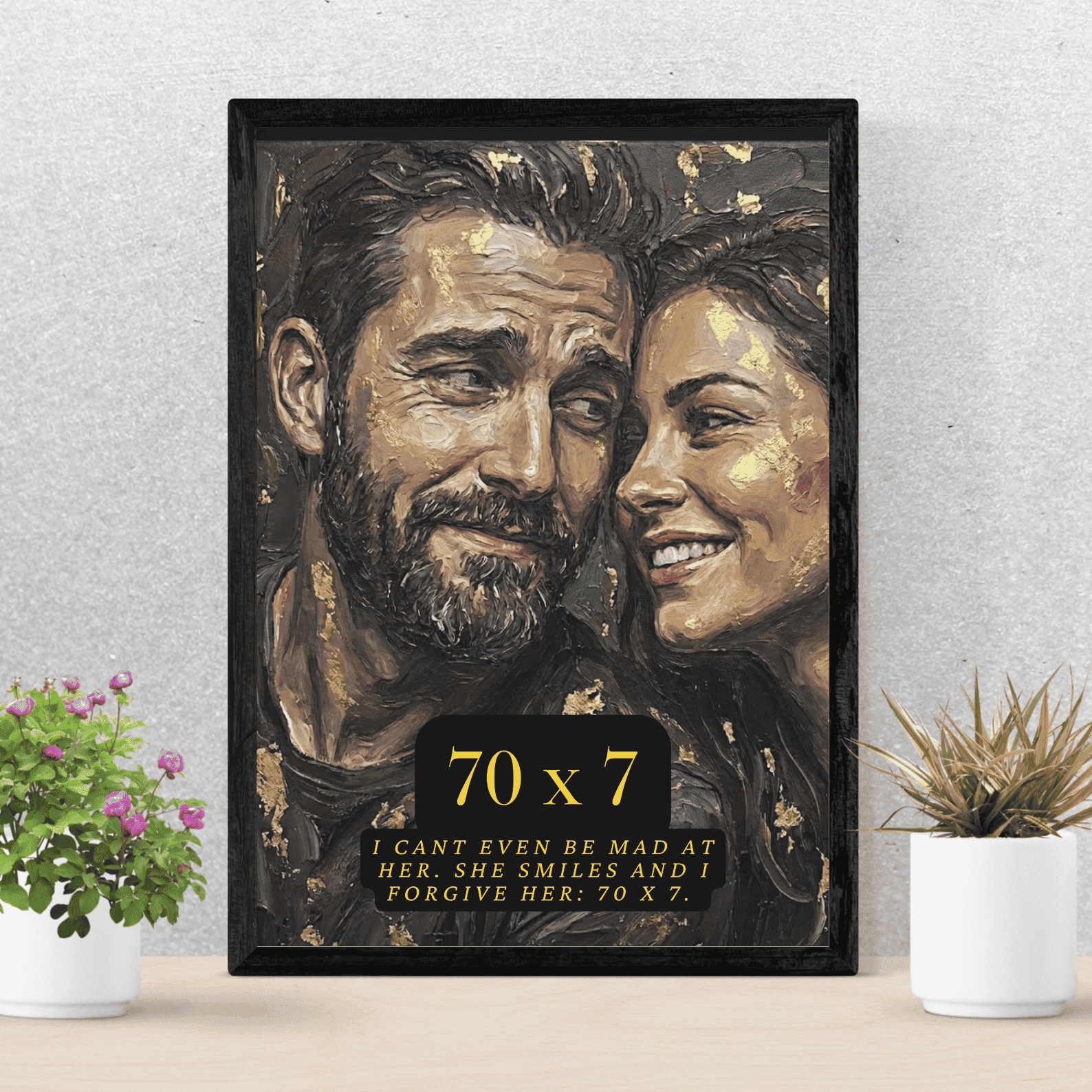 Framed artwork of a couple with a quote on a table with plants.