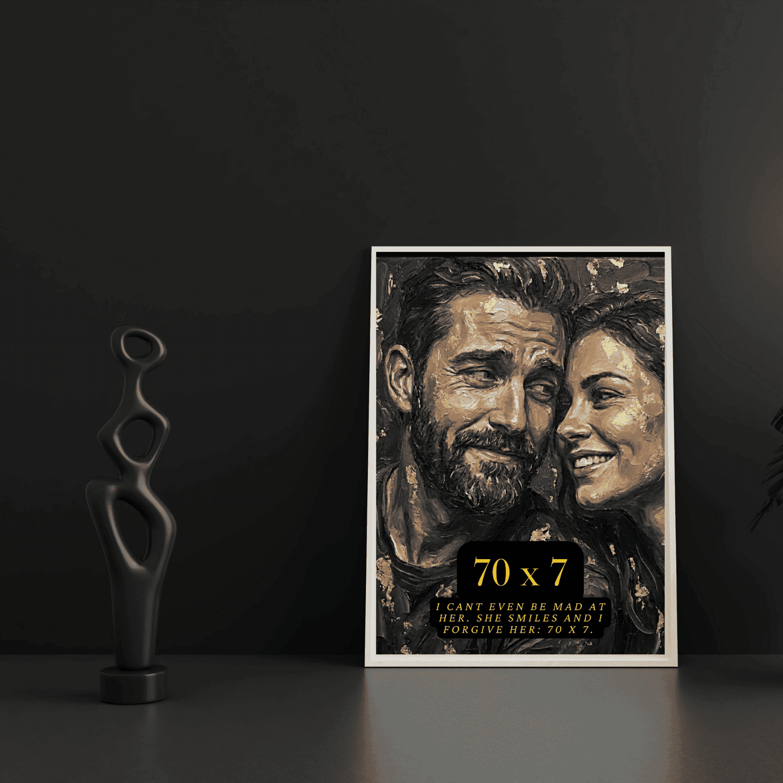 Framed artwork of a couple with text on a dark surface next to a sculpture.